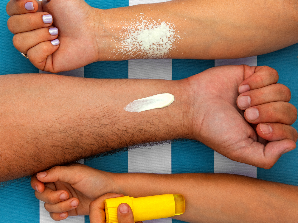 Mustela Lait Solaire, swatches on forearms and a child's hand holding a sun stick