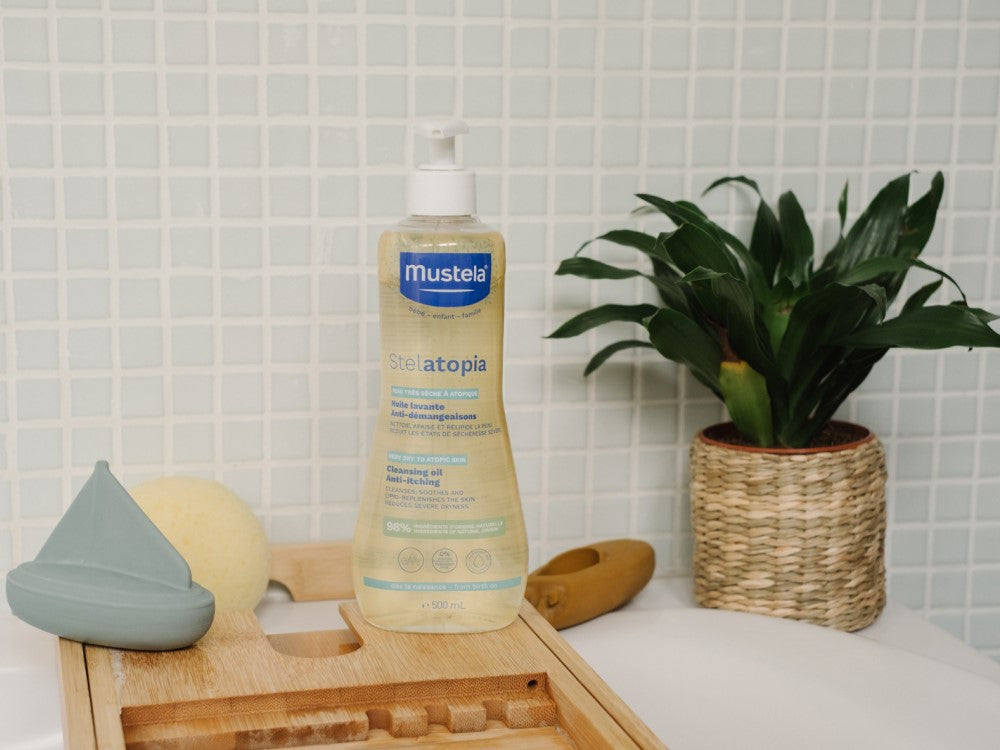 Mustela Stelatopia, pump bottle on a bath tray with a toy boat and sponge