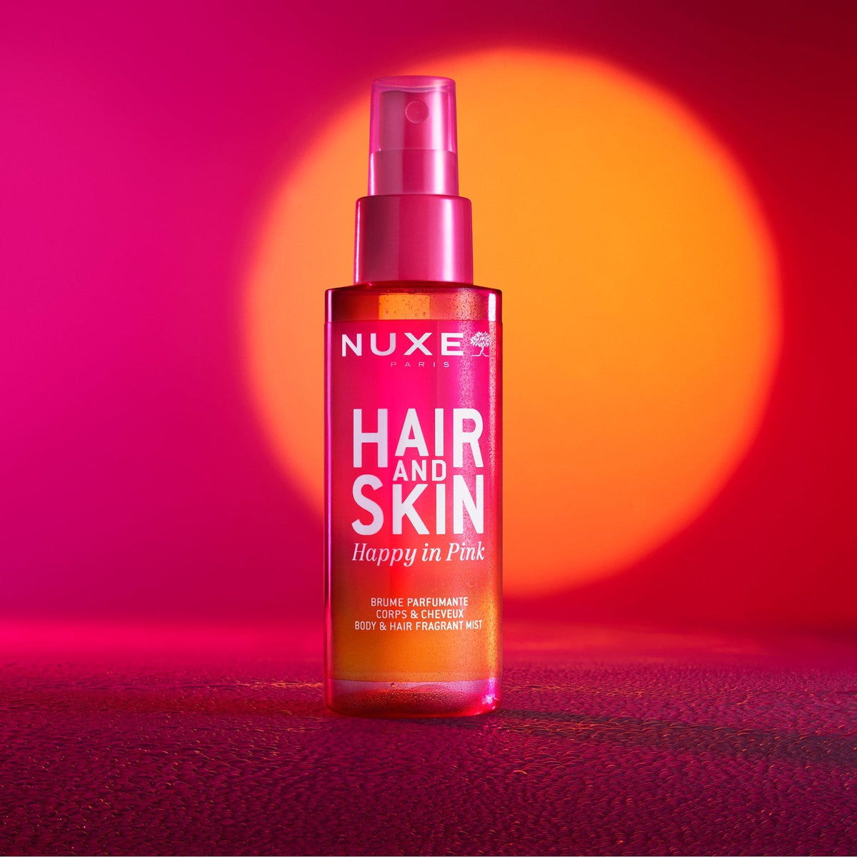NUXE Happy In Pink, spray bottle under pink and orange light