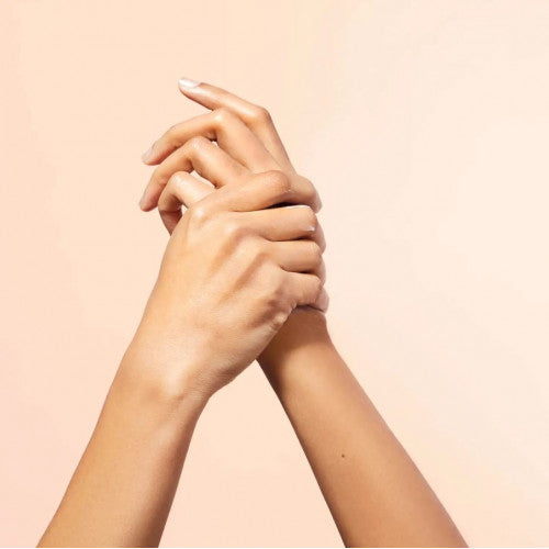 NUXE Honey Hand Cream, two hands clasped on a peach background