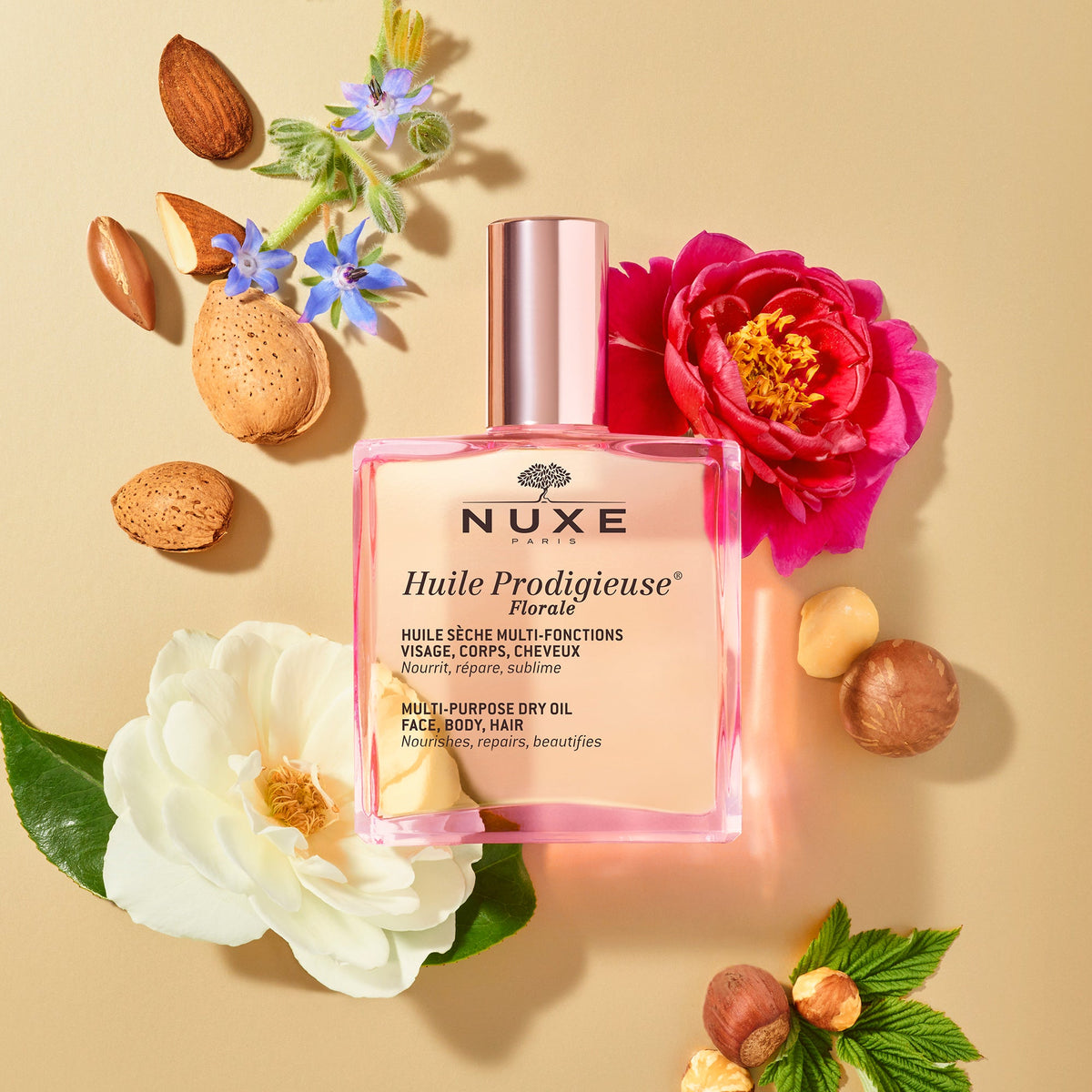 NUXE Huile Prodigieuse Florale, bottle among flowers, almonds and hazelnuts