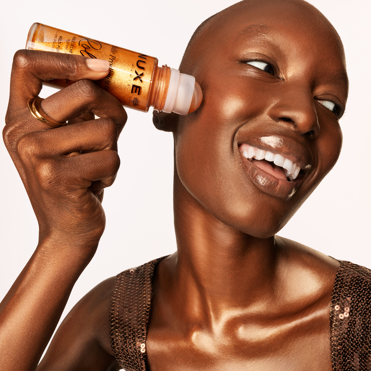 NUXE Huile Prodigieuse Gold Roll-On, applied to the face