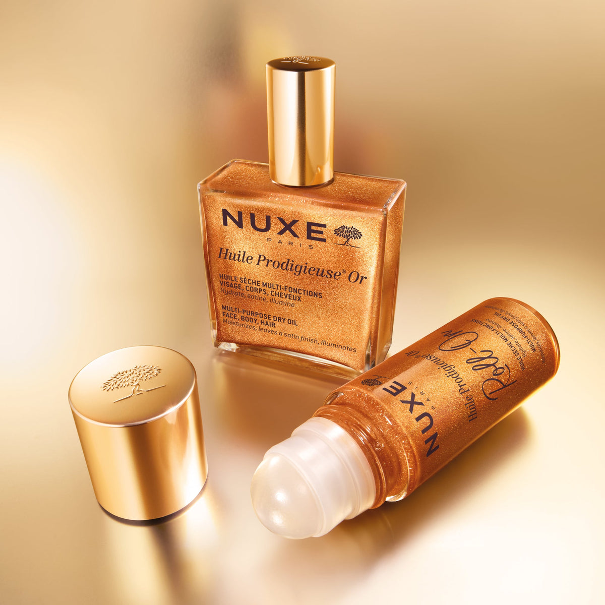 NUXE Huile Prodigieuse Gold Roll-On, open roll-on beside the Gold dry oil bottle