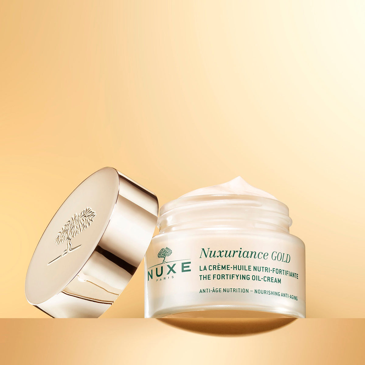 NUXE NUXURIANCE GOLD, open jar with its lid on a golden background