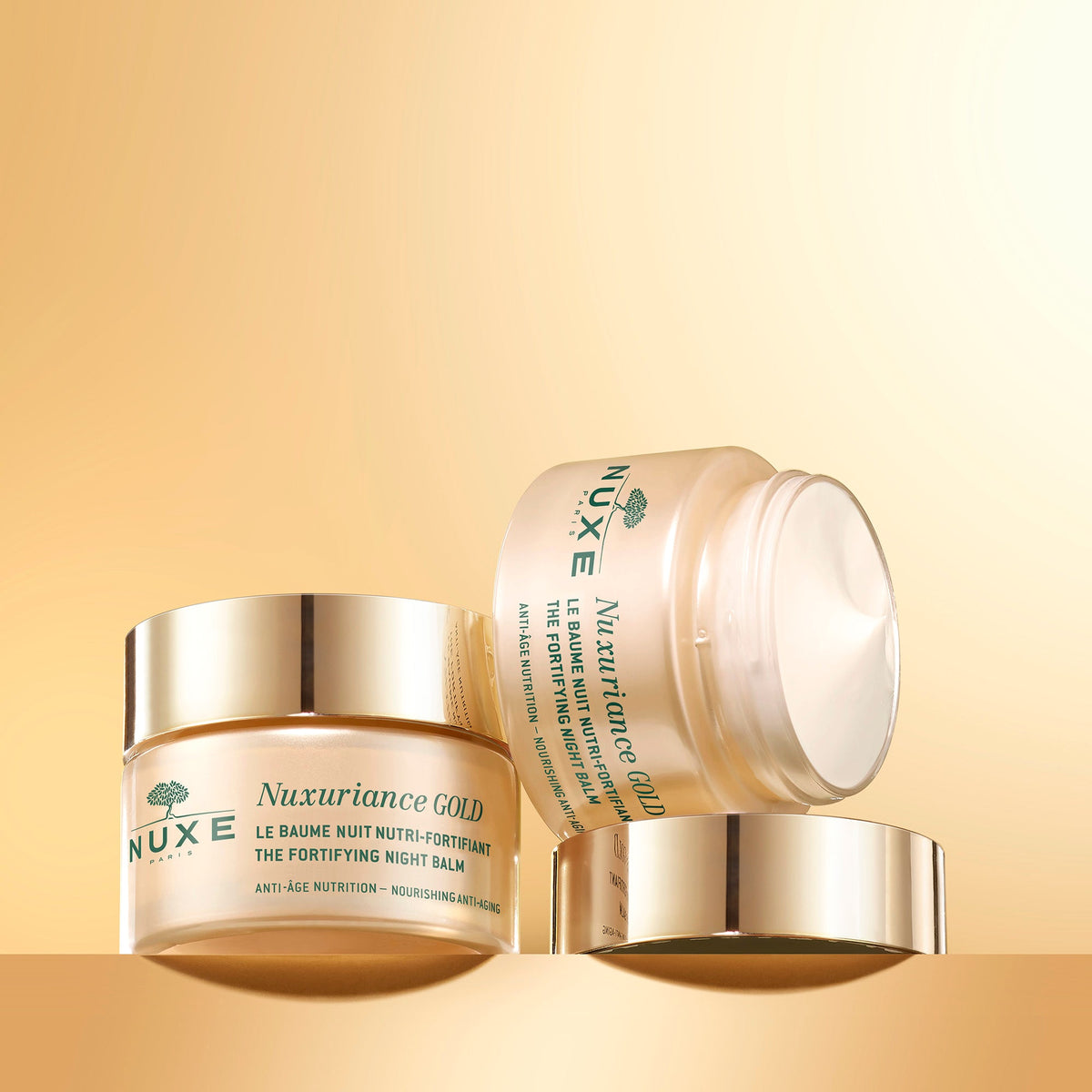 NUXE NUXURIANCE GOLD, closed jar beside an open jar tilted on its lid
