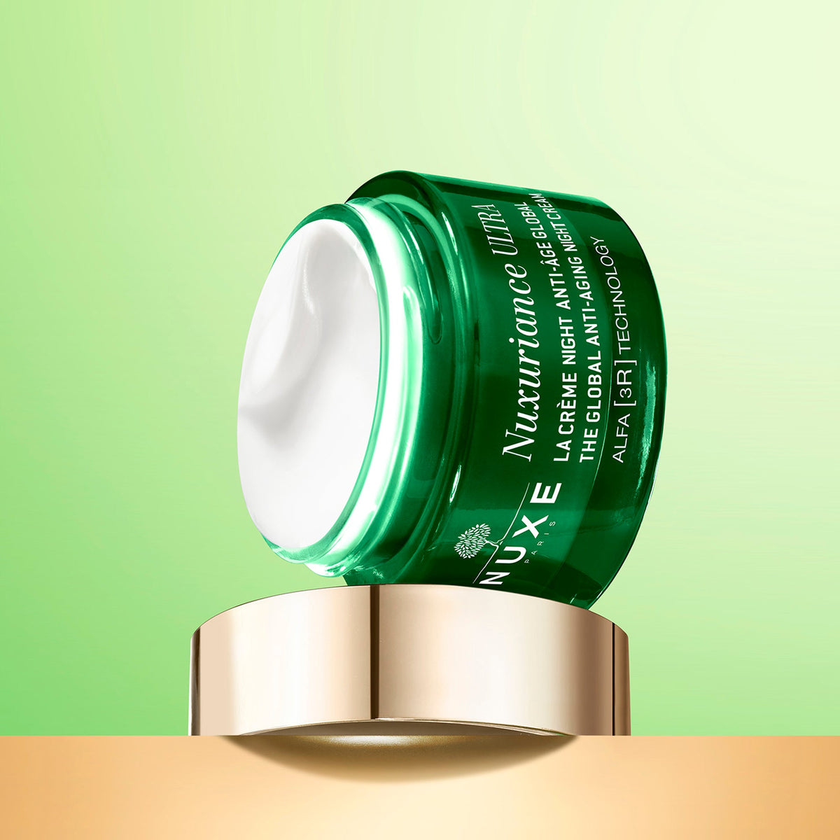 NUXE NUXURIANCE ULTRA, open jar tilted on its lid on a green background