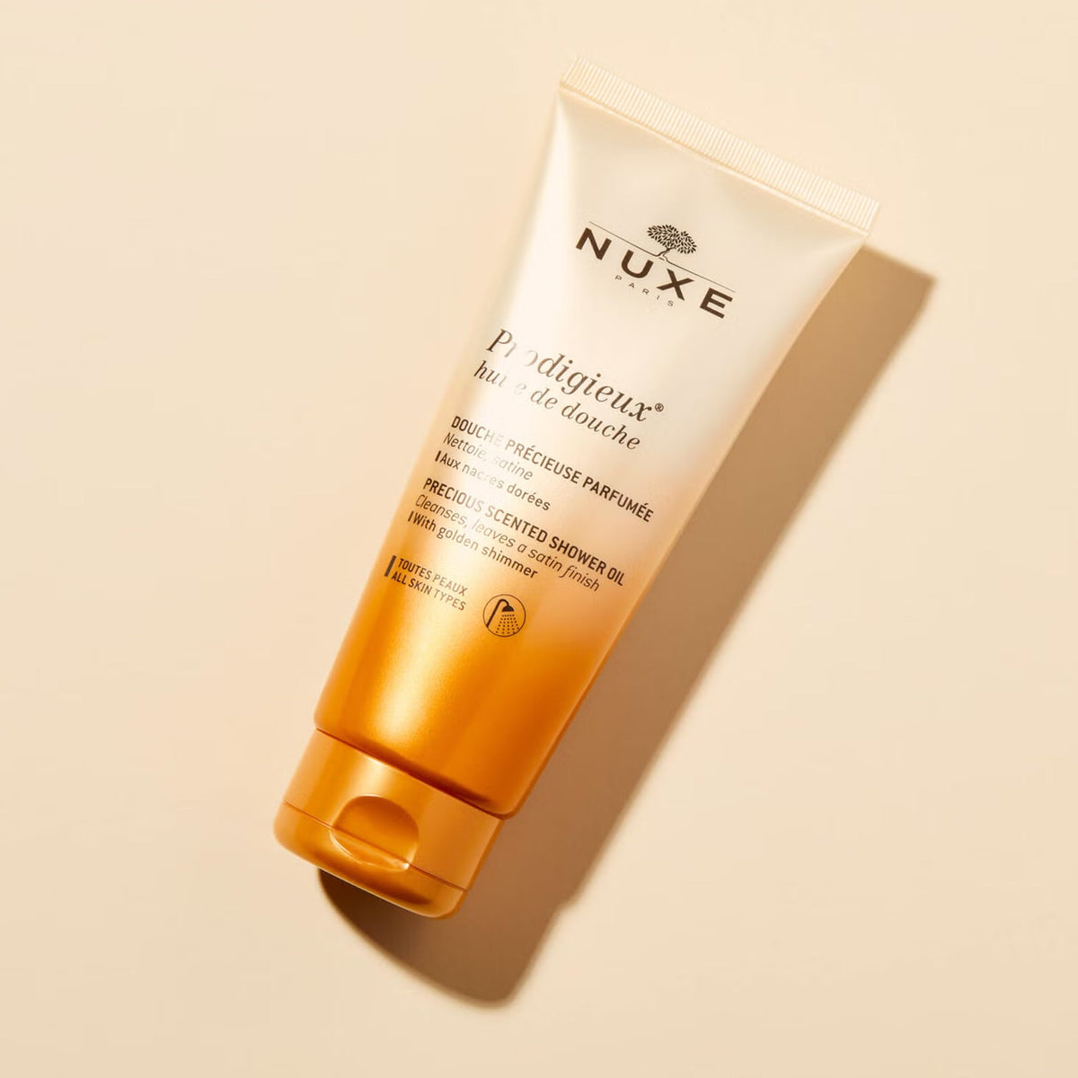 NUXE Prodigieux, tube lying on a beige background