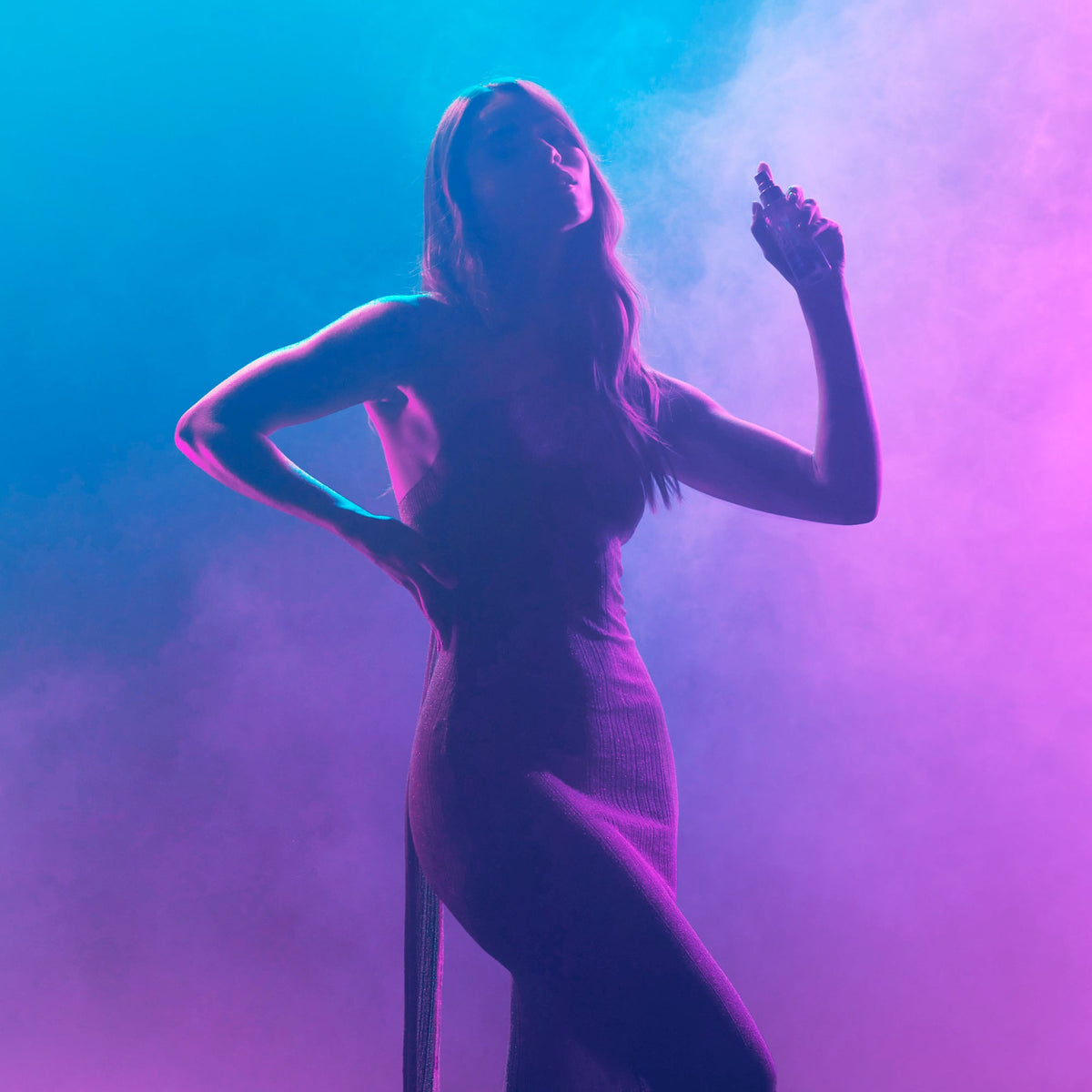 NUXE Hair and Skin Sensual Era, silhouette of a woman spraying mist in a purple haze