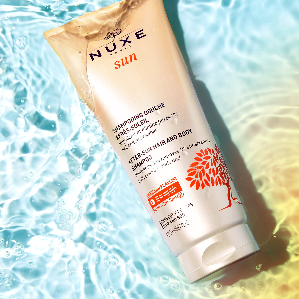 NUXE SUN, tube lying in rippled pool water