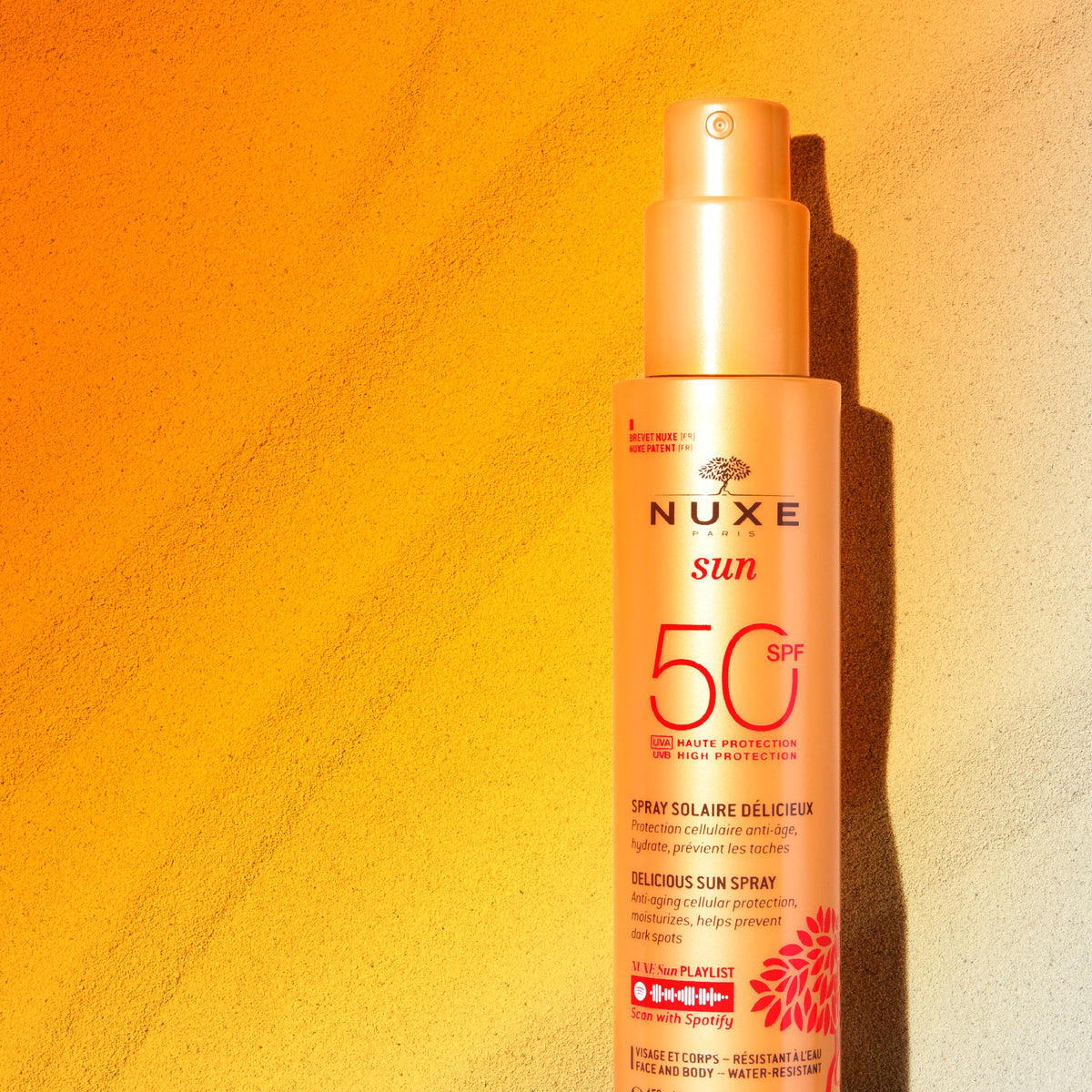NUXE SUN, spray bottle against a sunlit orange wall