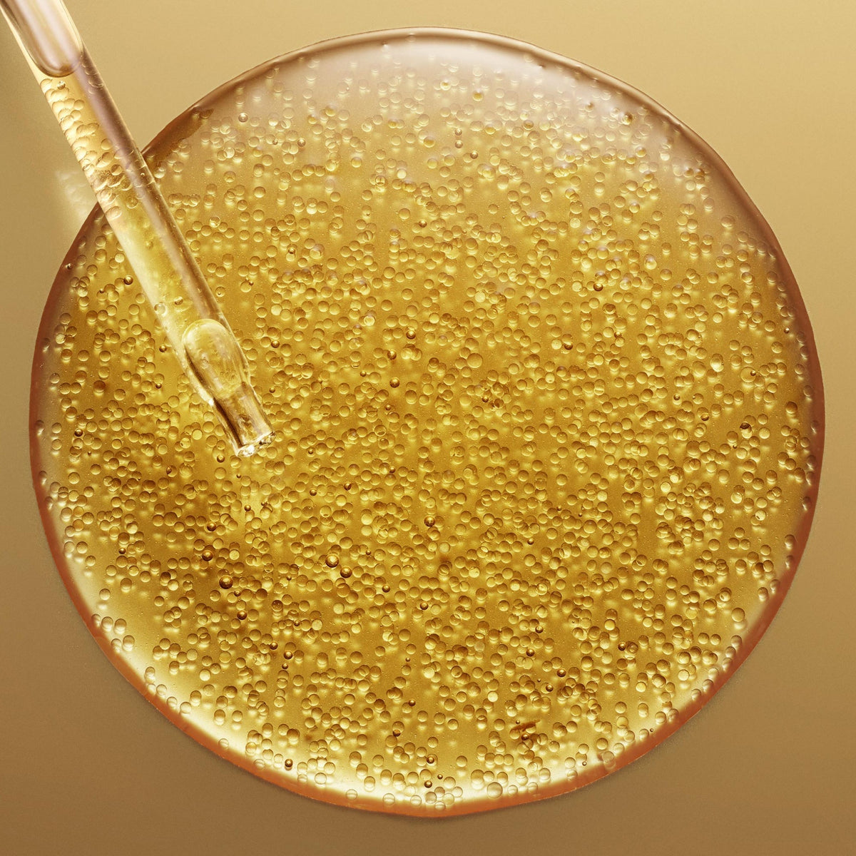 NUXE Super Serum [10], dropper over a pool of golden serum