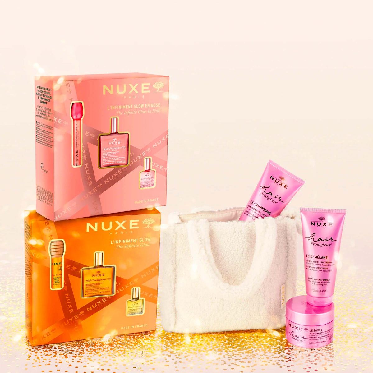 NUXE L'Infiniment Glow en Rose, stacked on the orange gift box beside a Hair Prodigieux bag