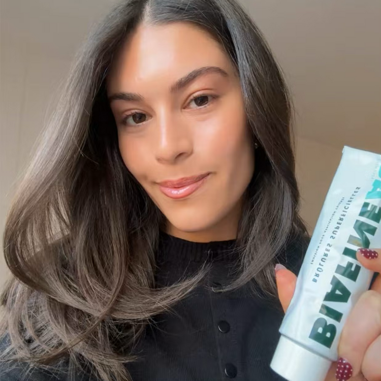 Woman holding BIAFINE emulsion with a close-up of the product on a beige background