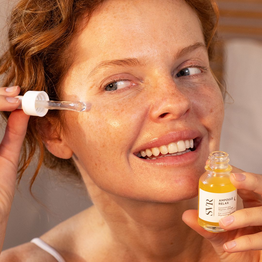 SVR AMPOULE RELAX, smiling woman holding the dropper under her eye