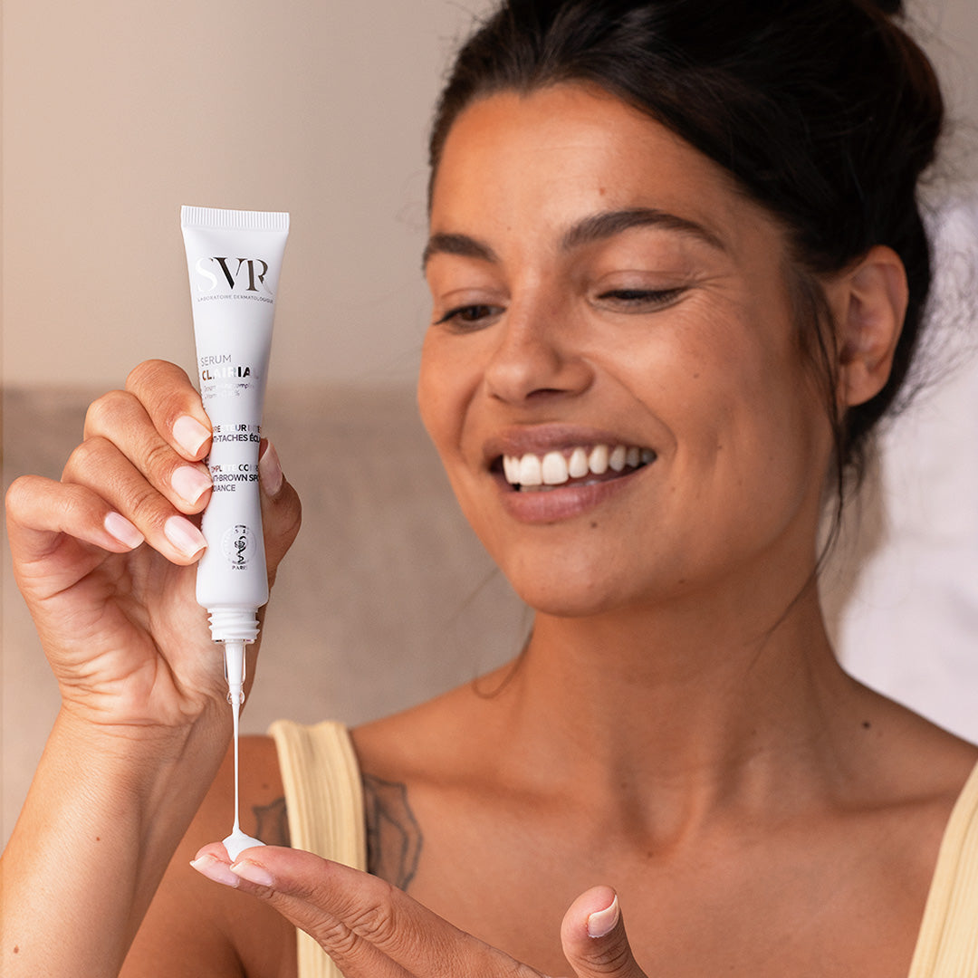 SVR Clairial, smiling woman squeezing the serum onto her fingertip
