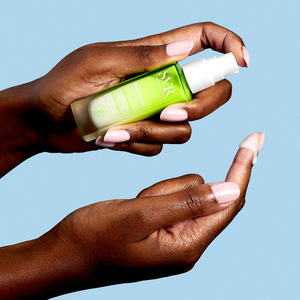 SVR Sebiaclear, hands holding the pump bottle with serum on a fingertip