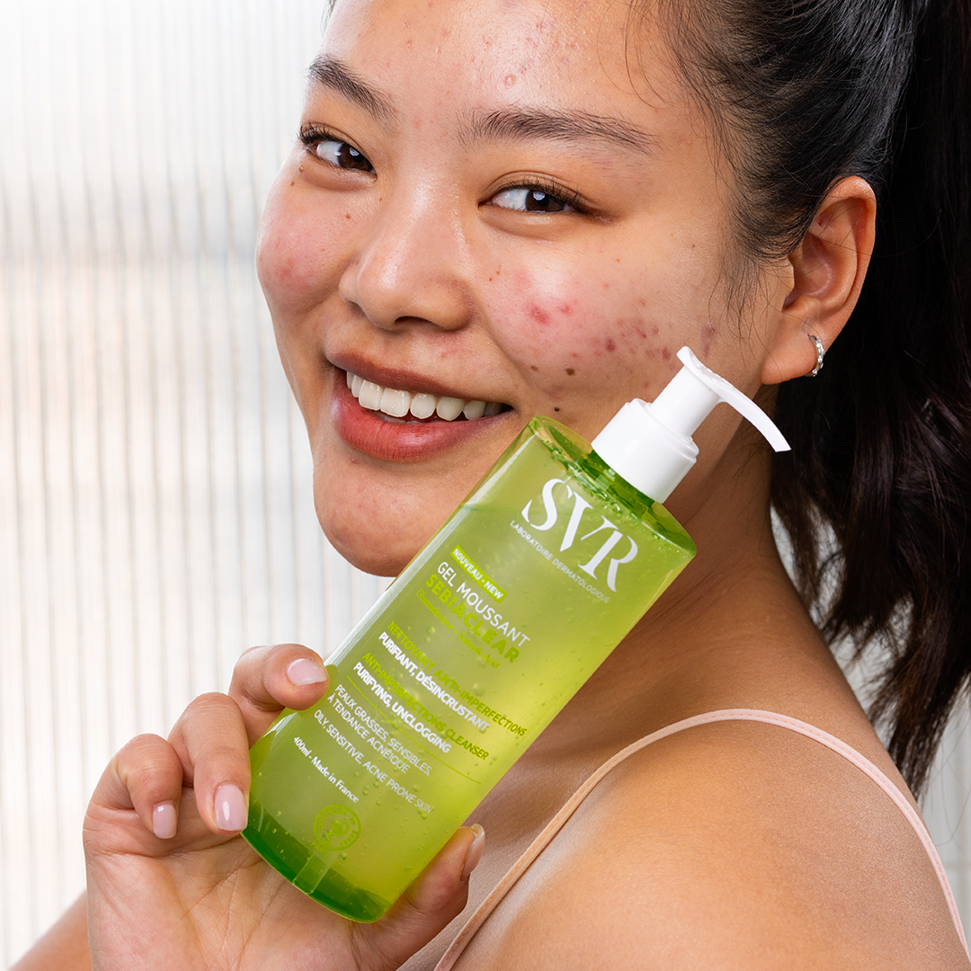 SVR Sebiaclear, smiling woman holding the pump bottle to her shoulder