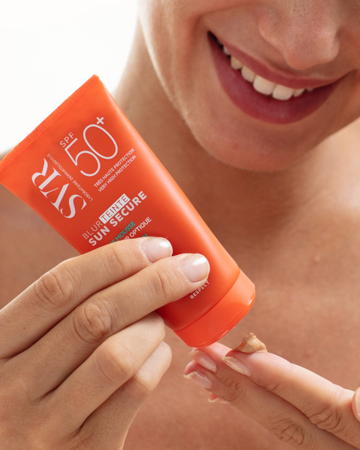 SVR Sun Secure, woman squeezing the tinted cream onto her fingertip
