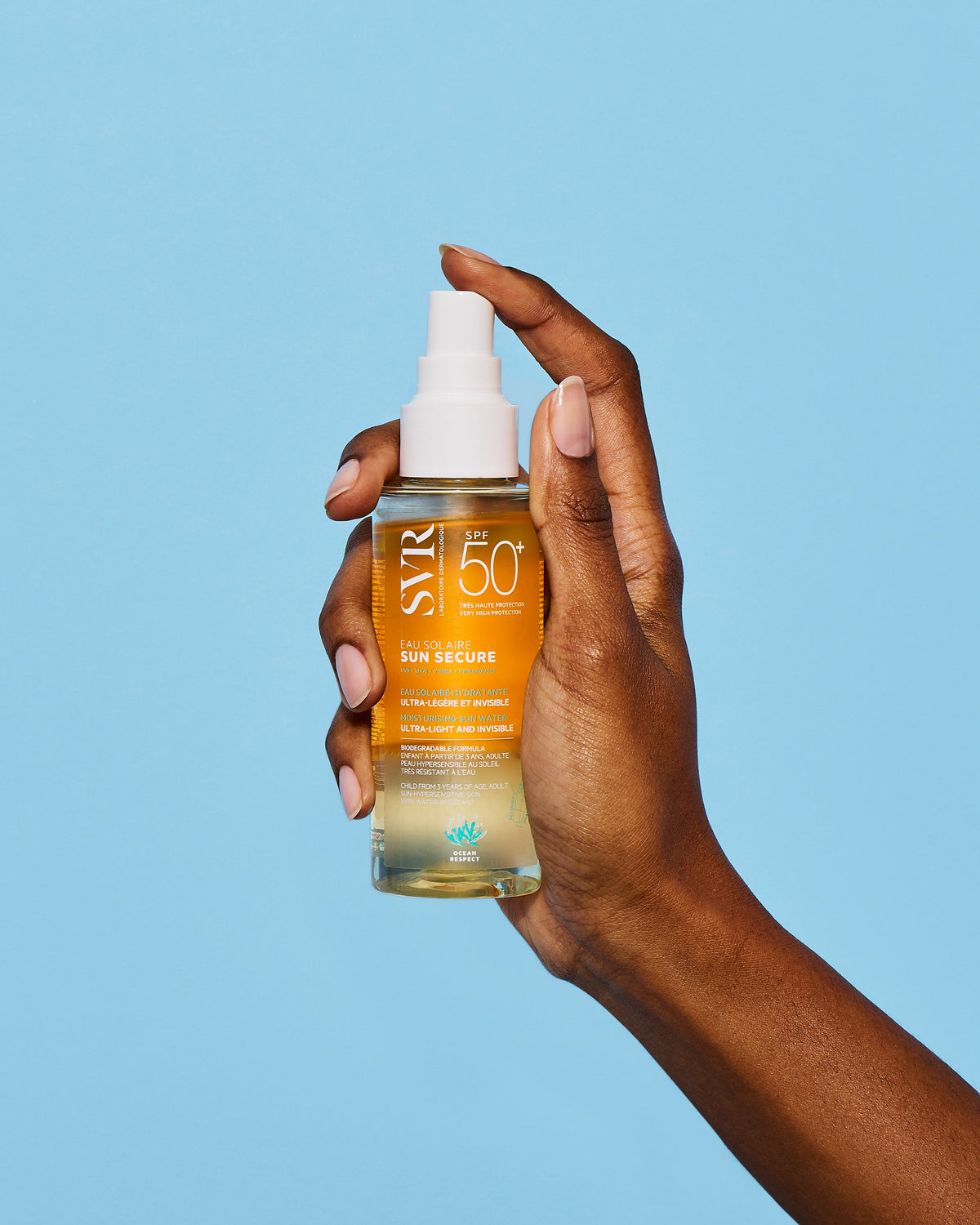 SVR Sun Secure, hand holding the spray bottle against a blue background