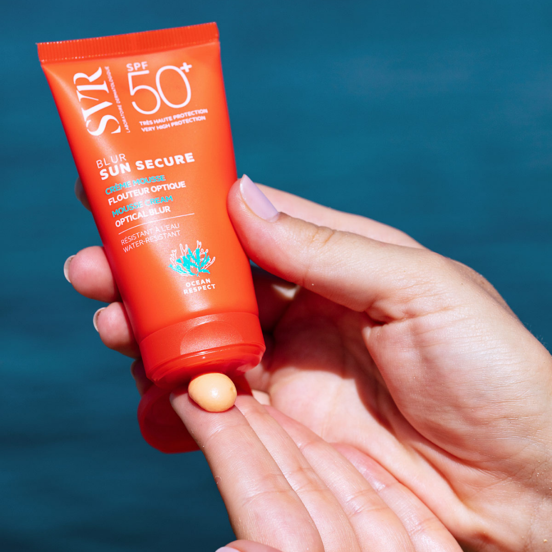 SVR Sun Secure, hands holding the tube with tinted cream on a fingertip