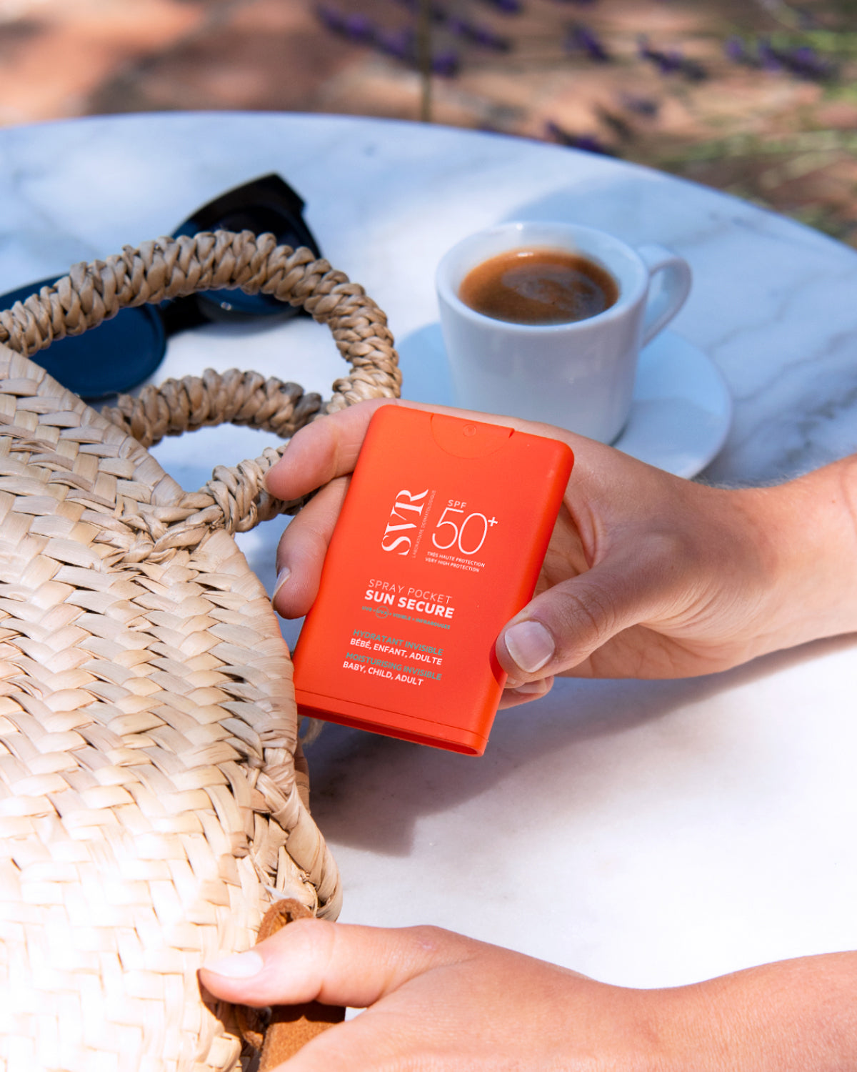 SVR Sun Secure, pocket spray going into a wicker bag beside a coffee cup