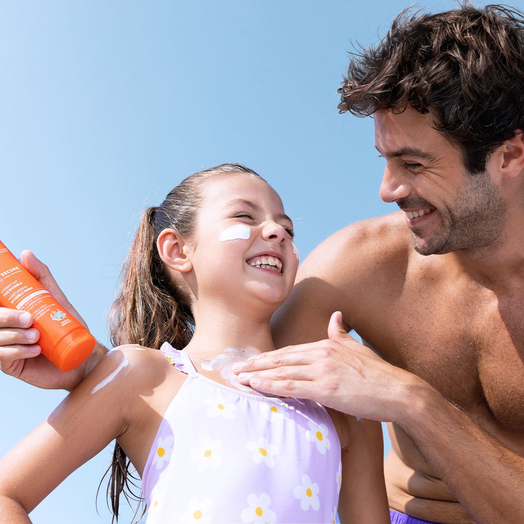 SVR Sun Secure, father applying milk to his laughing daughter's shoulder