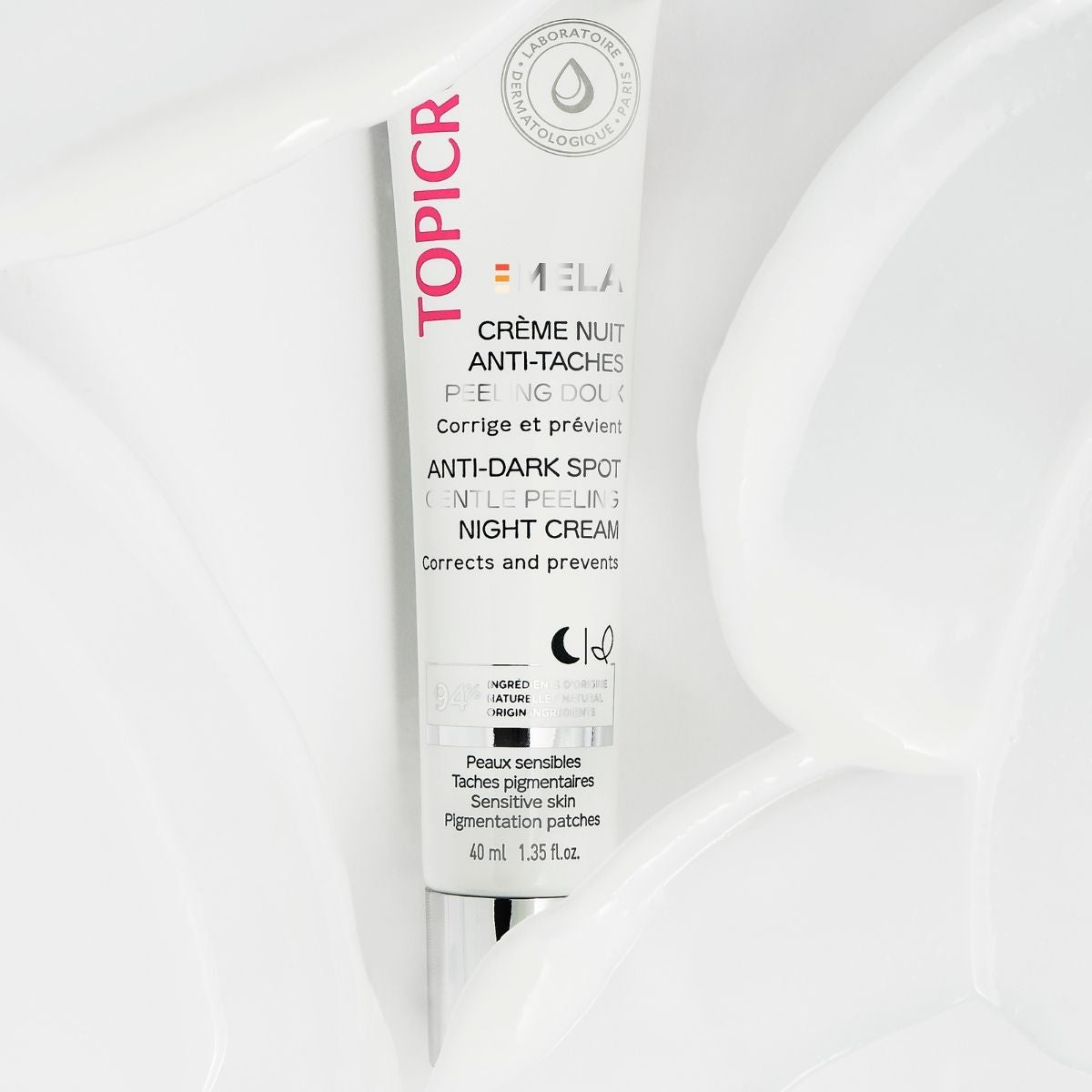 Topicrem MELA 40ml, tube lying on a bed of cream
