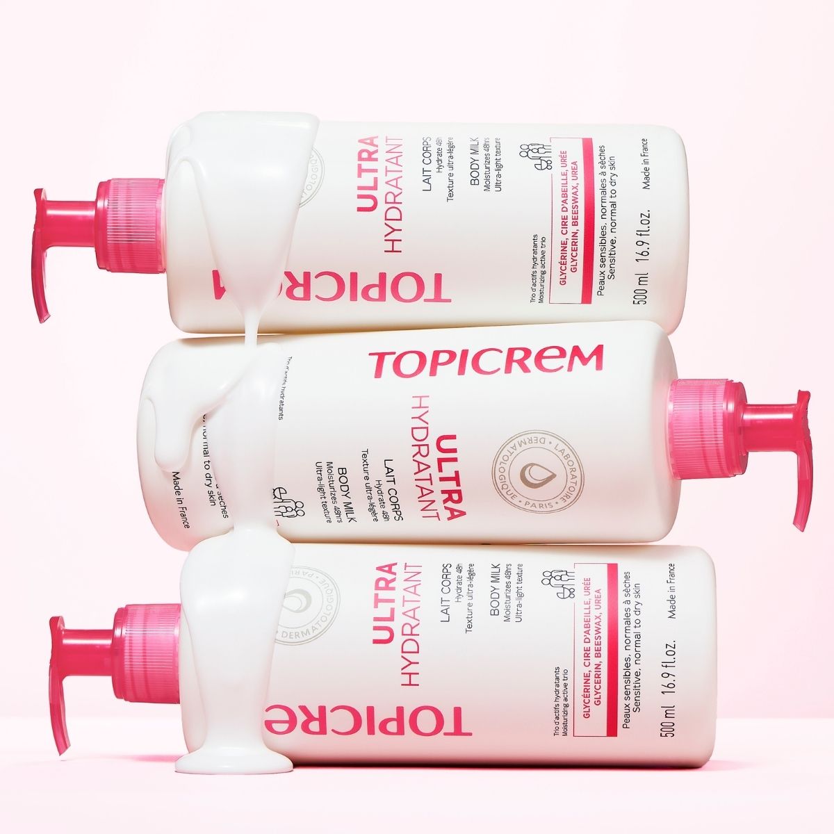 Topicrem Ultra Hydratant, three stacked pump bottles with dripping milk