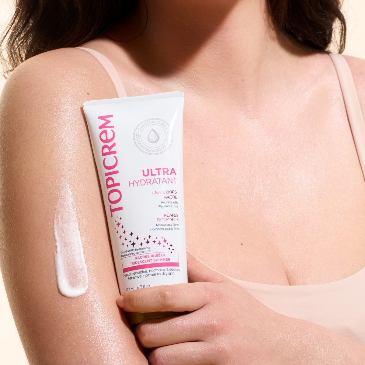 Topicrem Ultra Hydratant, woman holding the tube with a streak of milk on her arm