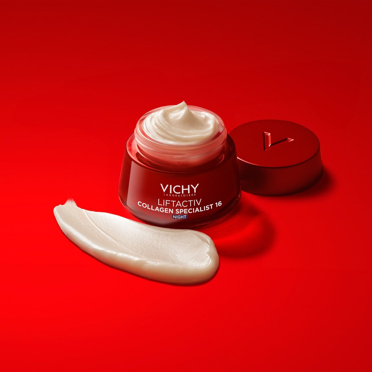 Vichy Liftactiv Collagen Specialist, open jar, lid and cream swatch on a red background